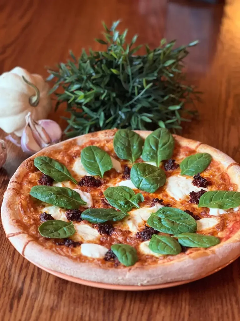 Pizza ze szpinakiem i mozzarellą na drewnianym stole